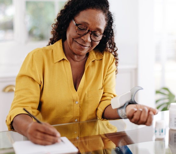 Chronic disease management: African American woman monitoring blood pressure at home